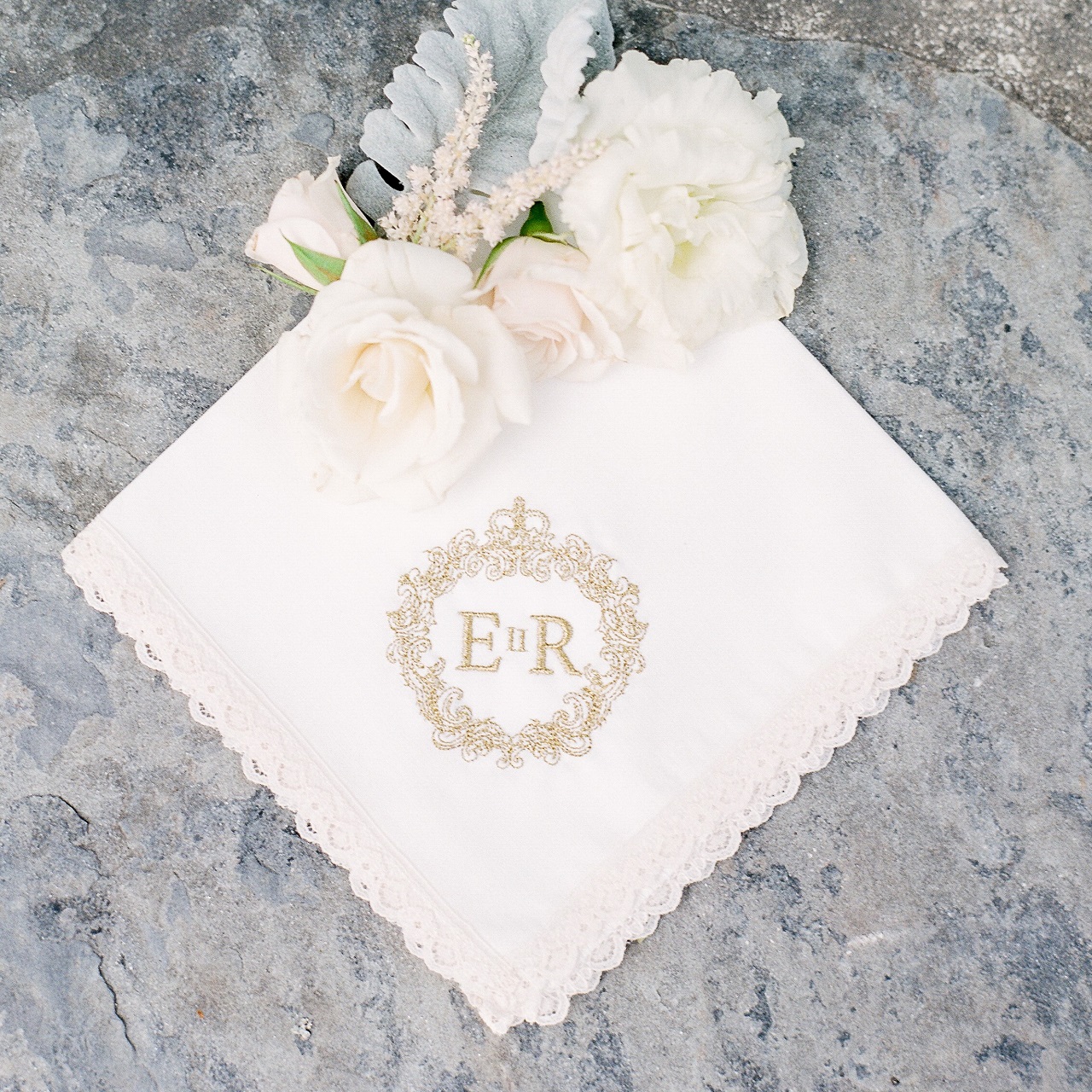 Custom embroidered wedding monogram on ivory handkerchief in gold thread.