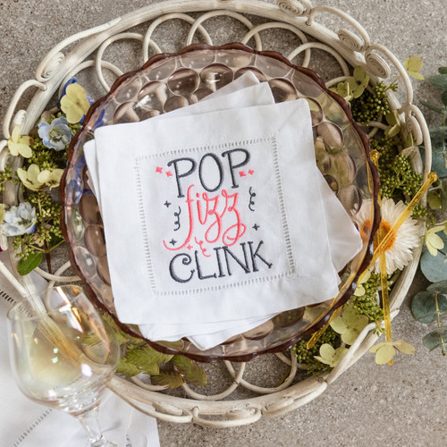 Custom embroidered cocktail napkins. Set of 4. Embroidered with the Pop Fizz Clink message and confetti in grey and hot pink thread Background has flowers and a glass.