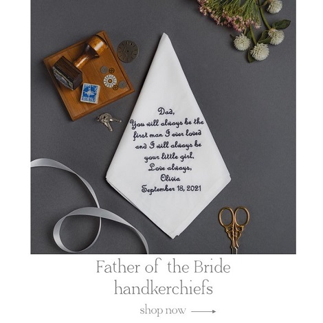 Father of the bride white handkerchief embroidered with a customized name and date on a grey background.