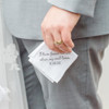 Groom holding his personalized embroidered wedding handkerchief. White handkerchief with grey embroidery thread.