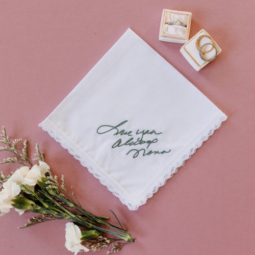 Handwriting embroidered on a white lace handkerchief in sage embroidery thread. 