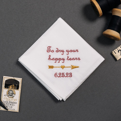 Happy tear white handkerchief with embroidered message, personalized date and arrow in matte gold.
