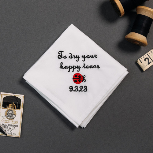 Happy tear white handkerchief with embroidered message, personalized date and ladybug in black and red.