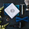 Groom wedding accessories including a white handkerchief with monogram in navy