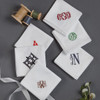 Monogrammed men's white handkerchiefs with embroidered monograms in various colors. 