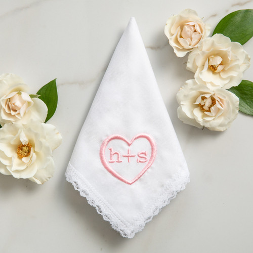 Monogrammed initials on white lace bridal handkerchief embroidered in cotton candy pink. Roses are also shown.