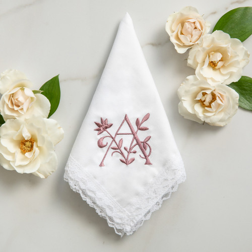 Women's white lace handkerchief embroidered with a floral monogram in a dusty rose thread. 