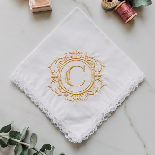 Monogrammed white lace women's handkerchief with embroidered initial.
