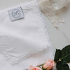 Picture of the sewn tag to show it is made in the USA by The Handkerchief Shop. Handkerchief is shown in white fabric with white lace.